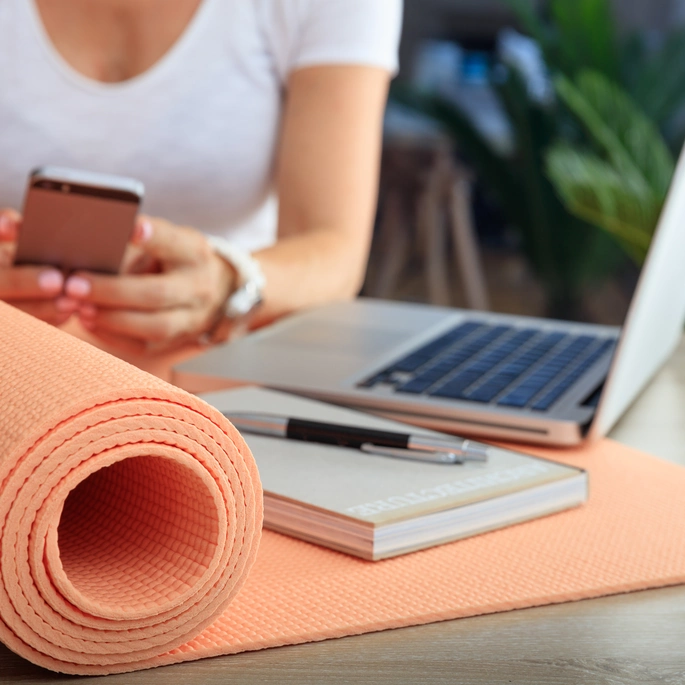 Block, Stift, Laptop und Sportmatte